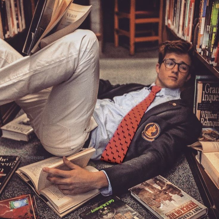 A student at ease among library stacks in a navy blazer